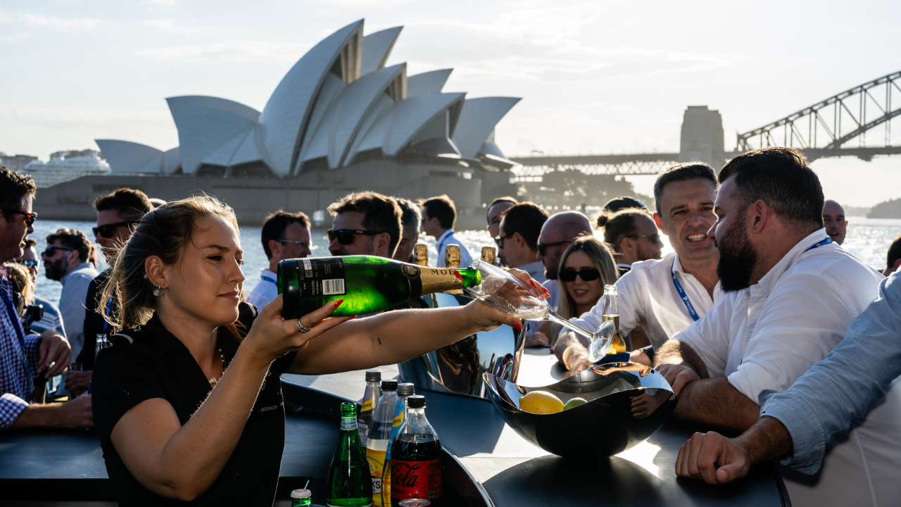 Woman pouring champaign with the Sydney Opera House in the background